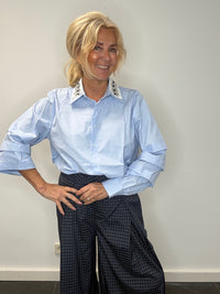 Light blue blouse with a white collar and rhinestones